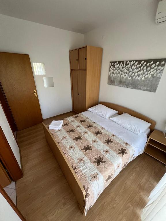 a bedroom with a bed and a cabinet in it at Economy room with kitchenette in Grebaštica