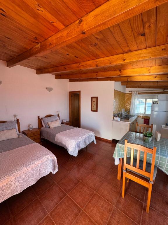 a room with two beds and a table and a kitchen at Apartamento junto al mar El Roque in Santa Cruz de Tenerife