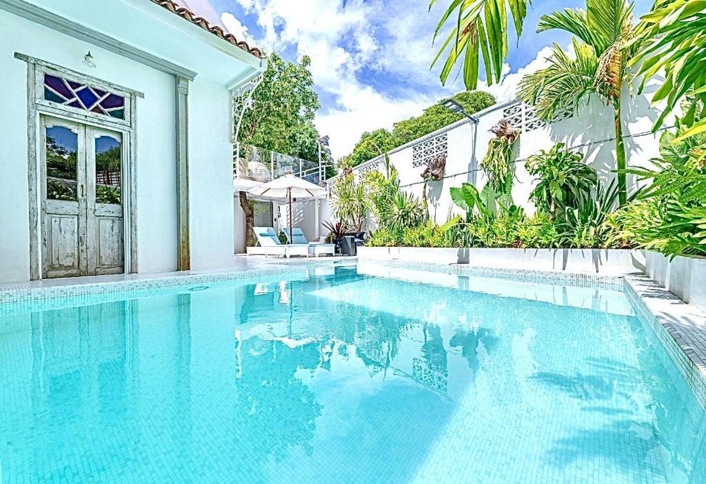 une piscine devant une maison dans l'établissement Santitham Pool Villa I 5 Bedrooms I walkable I Entire villa I Daily Housekeeping, à Chiang Mai