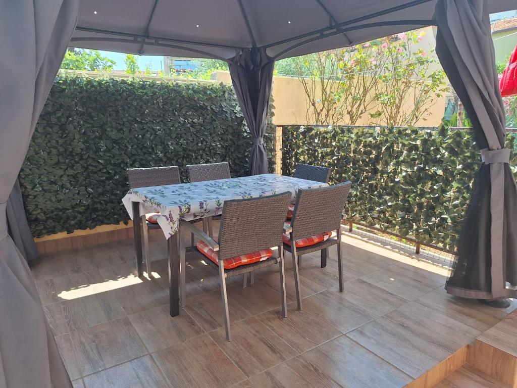 a table and chairs sitting under a canopy on a patio at Apartments Margareta in Novigrad Istria