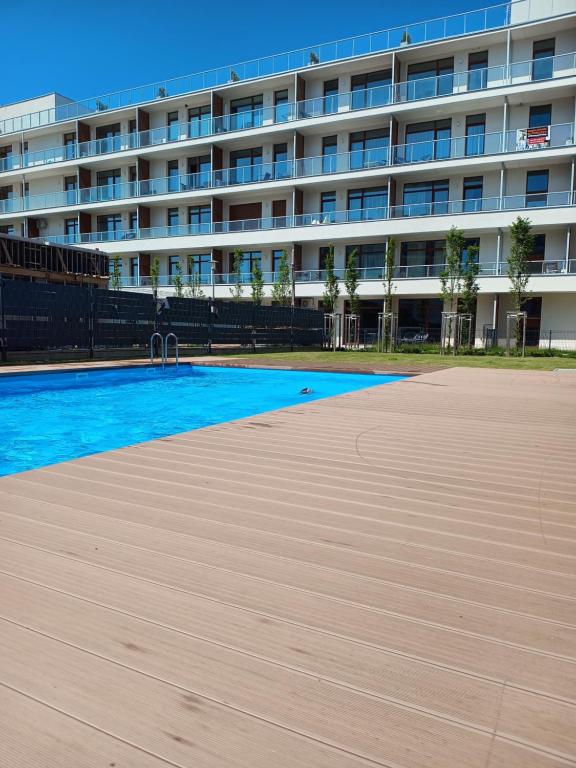 an empty swimming pool in front of a building at Apartament Grey 52, 3 min od plaży, basen, plac zabaw, darmowy parking! in Sianozety