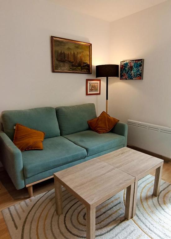 - un salon avec un canapé vert et une table basse dans l'établissement Cozy independent studio, à Roussillon