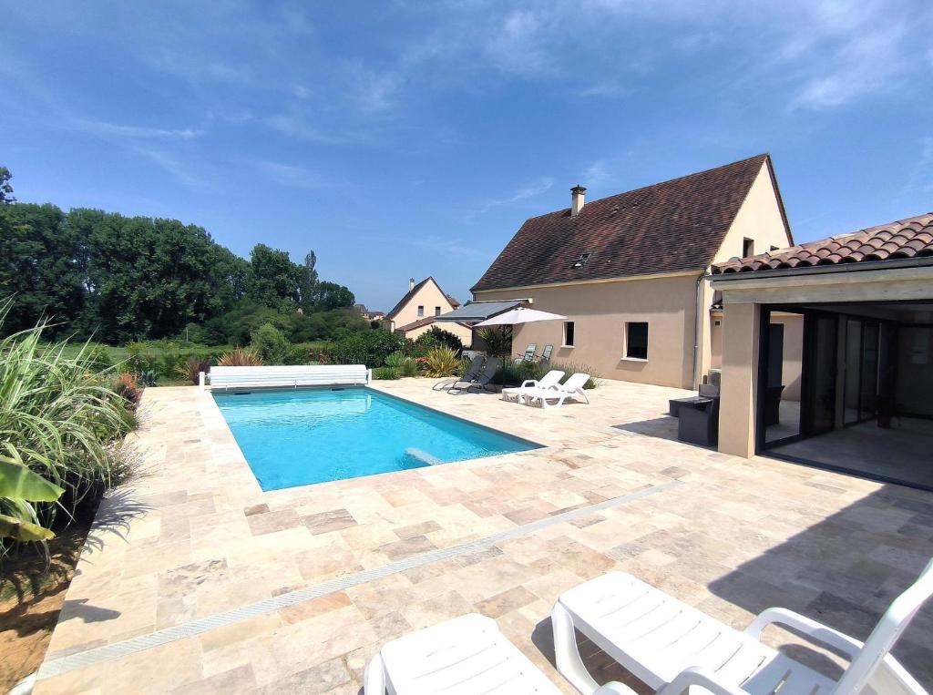 a backyard with a swimming pool and a house at Villa Poujol en Dordogne, piscine chauffée in Saint-Crépin-et-Carlucet
