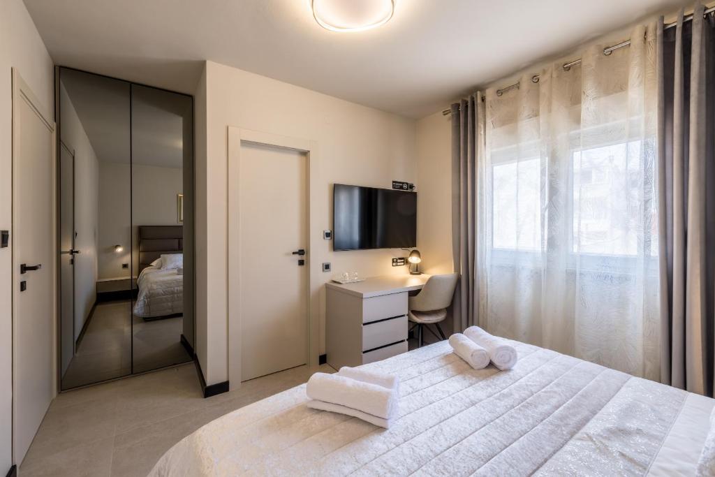 a bedroom with a bed and a desk and a television at Guesthouse Rooms Split in Split