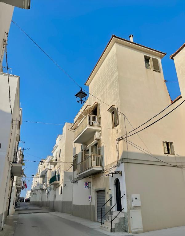 a tall white building on a street at Nicole's House in Vieste