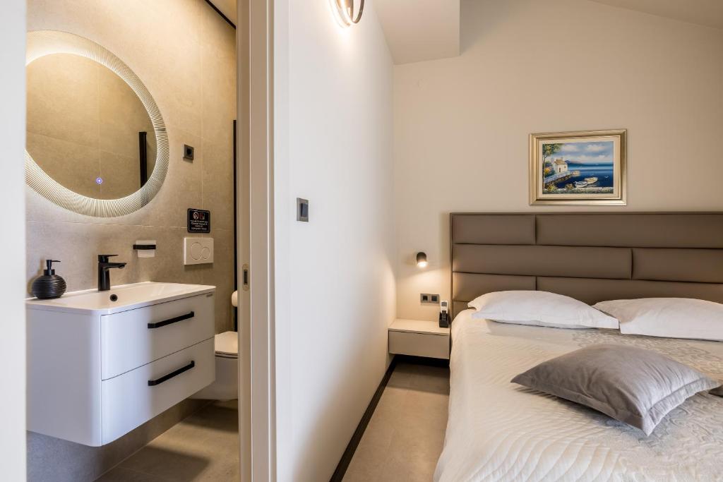 a bedroom with a bed with a sink and a mirror at Guesthouse Rooms Split in Split