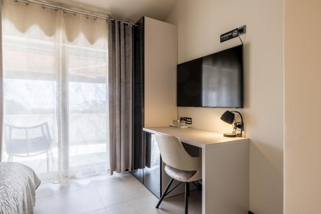 a bedroom with a desk with a tv and a window at Guesthouse Rooms Split in Split