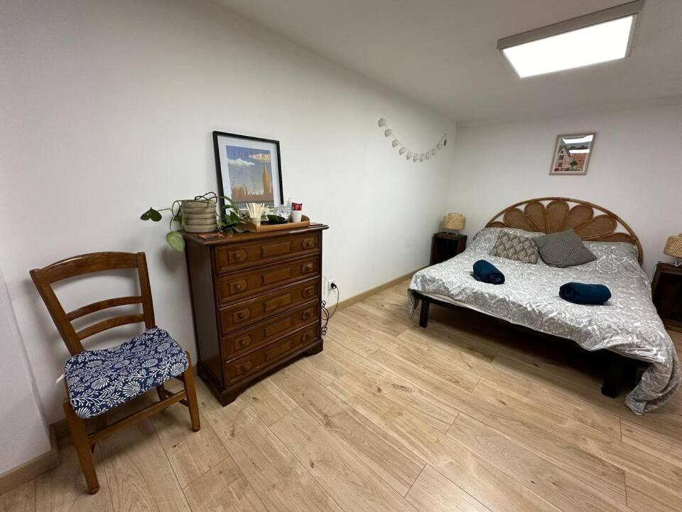 a bedroom with a bed and a dresser and a chair at Ananda in Le Mans