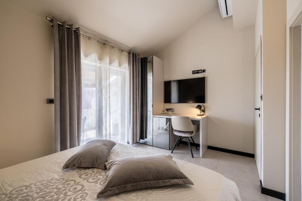a bedroom with a bed and a desk and a television at Guesthouse Rooms Split in Split
