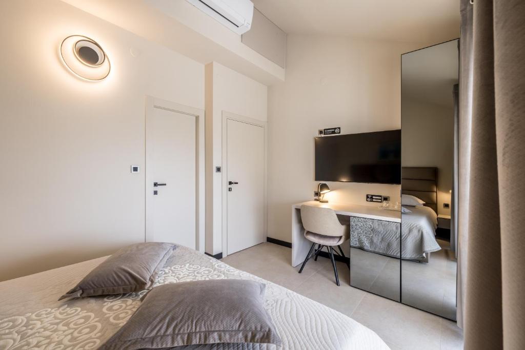 a bedroom with a bed and a desk with a television at Guesthouse Rooms Split in Split