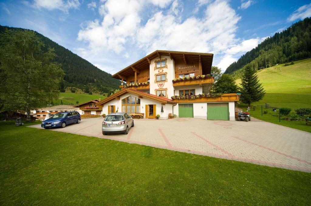 um grande edifício com carros estacionados num parque de estacionamento em Gästehaus Alpenblick em Berwang