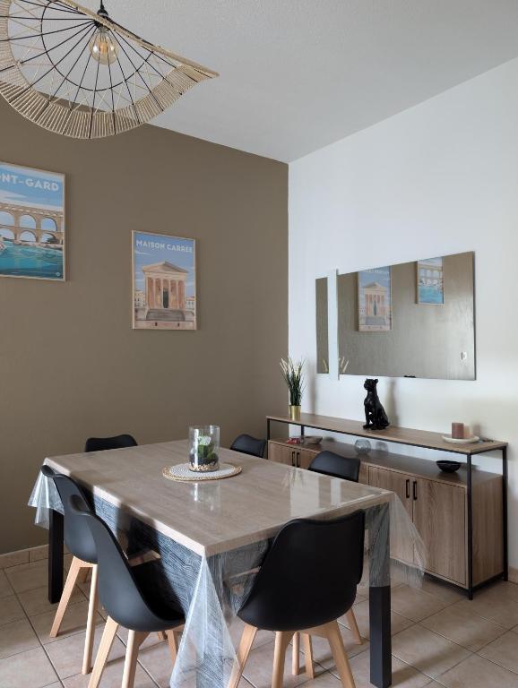 une salle à manger avec une table et des chaises dans l'établissement Uzès centre à 2 min - piscine - clim - parking, à Uzès