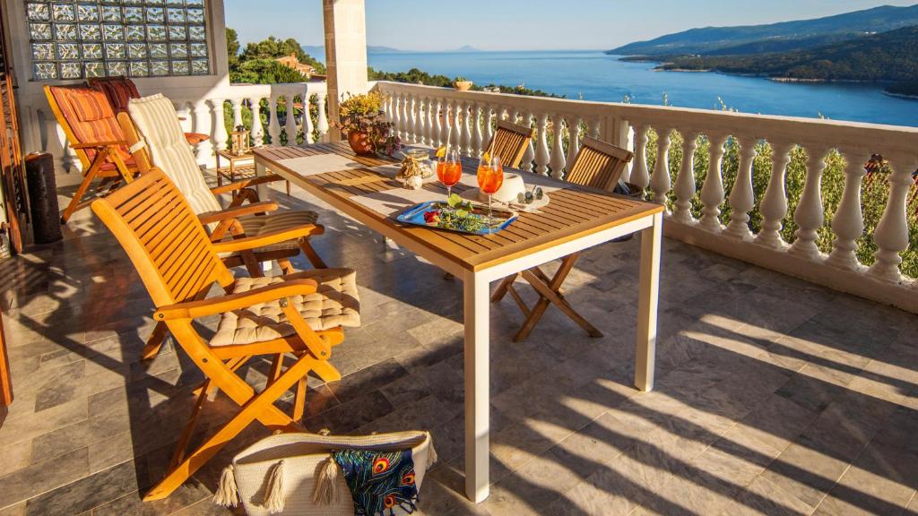 a wooden table and chairs on a balcony at La casa di Marko Sea View Apartments in Rabac