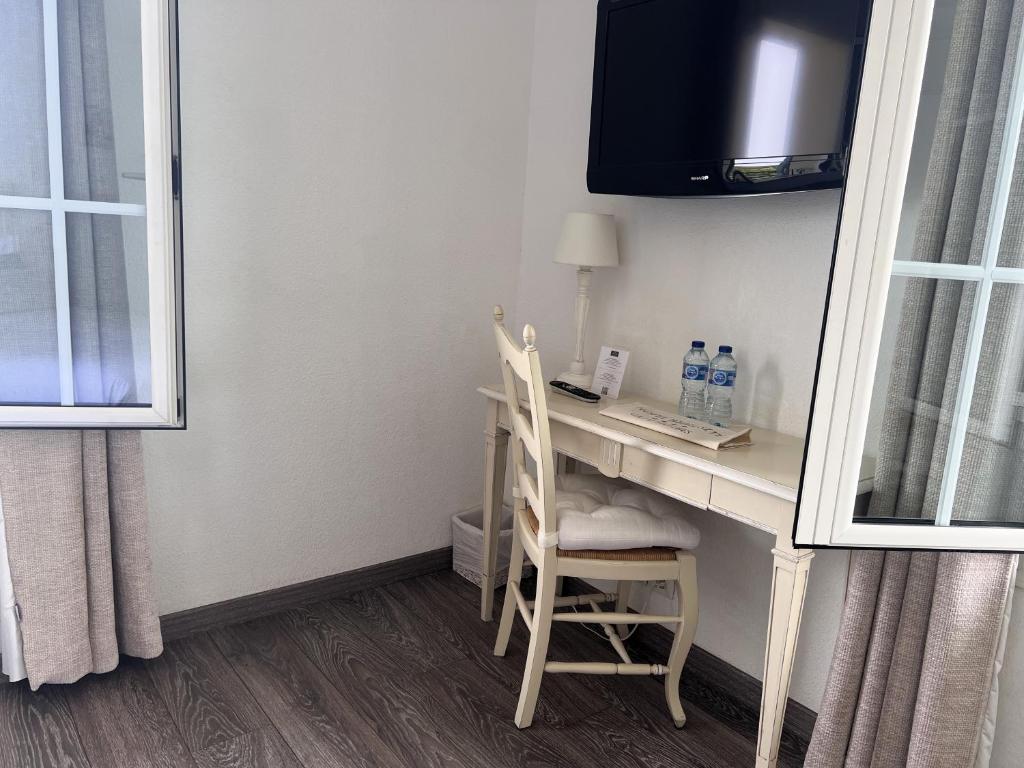 a room with a desk with two chairs and a computer at Hôtel Beau Site - Cap d'Antibes in Antibes