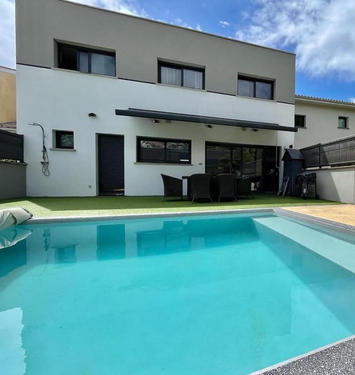 une maison avec une piscine devant une maison dans l'établissement Le soleil de pessac, à Pessac