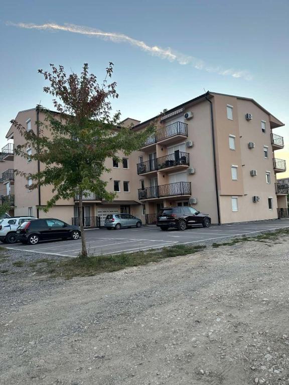 a large building with cars parked in a parking lot at Nobus Vila jezero in Veliko Gradište