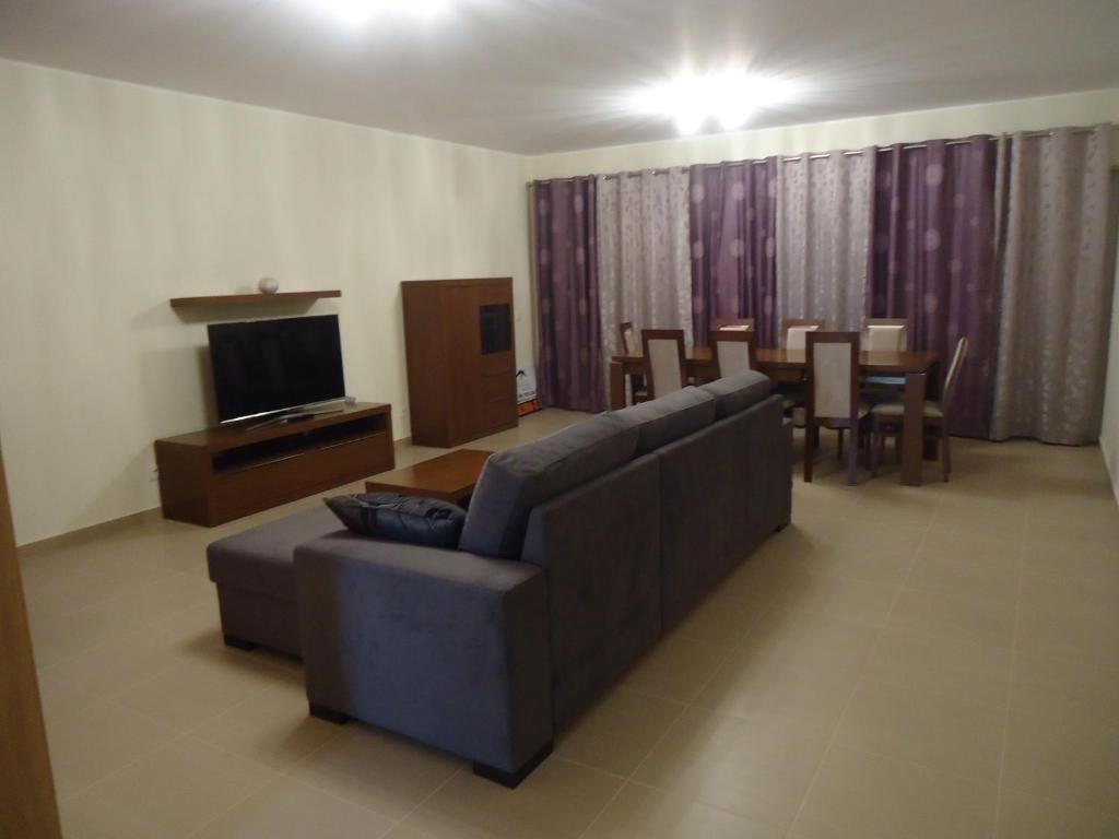 ein Wohnzimmer mit einem Sofa und einem Esszimmer in der Unterkunft Apartamento Gamboa-Frente à Praia in Peniche