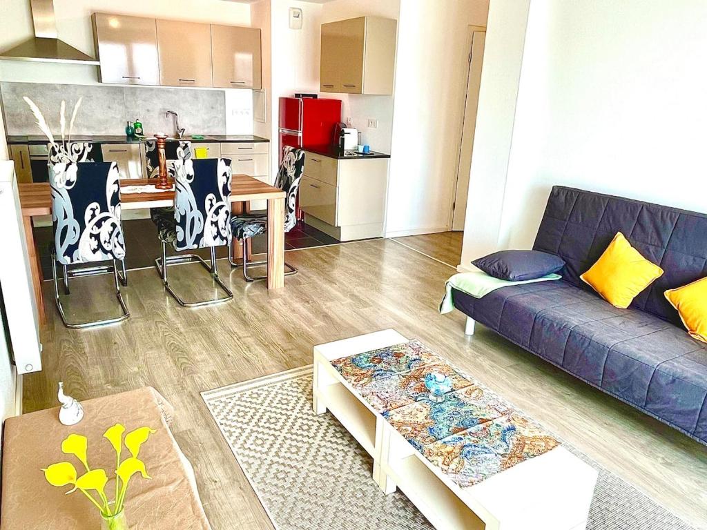 Il comprend un salon avec un canapé violet et une cuisine. dans l'établissement Charmant T3 avec balcon et parking, à Strasbourg