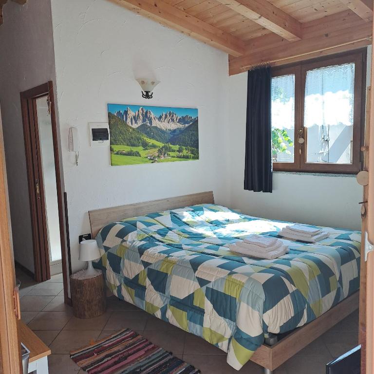 a bedroom with a bed and a window at Valtellina Grosotto Holidays in Grosotto