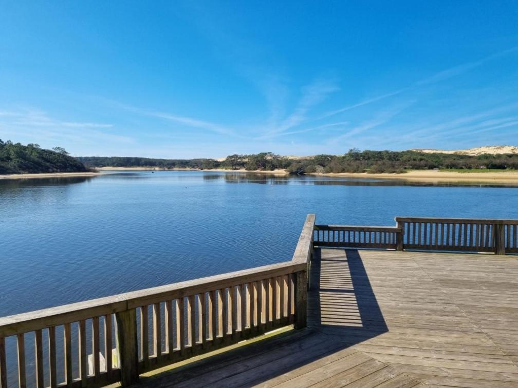 a wooden deck with a view of a river at Appartement Lac marin in Vieux-Boucau-les-Bains