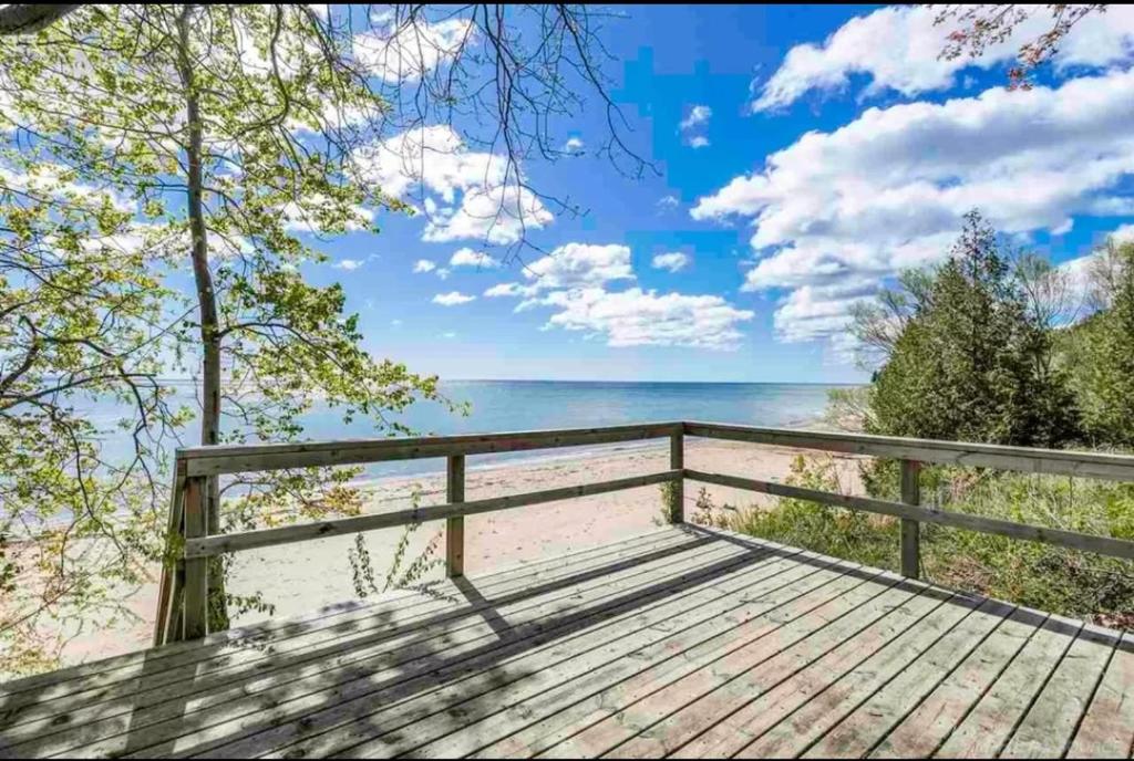 Una terraza de madera con vistas a la playa. en Serenity Lake House, en Palms