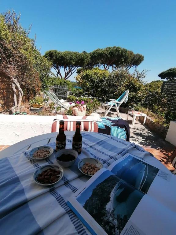 une table avec de la nourriture et deux bouteilles de bière dans l'établissement La Pointe de Sel - Plage a 2 minutes a pied, à Lumio