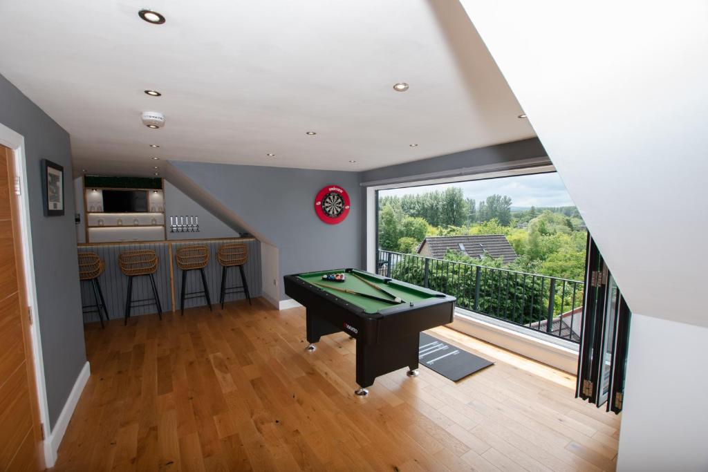 a living room with a pool table and a balcony at Penthouse at the White House near Edinburgh in Bathgate