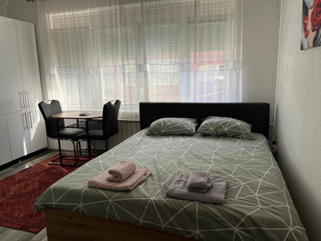 a bedroom with a bed with two towels on it at Stan na dan, Pazar Tuzla - centar grada in Tuzla