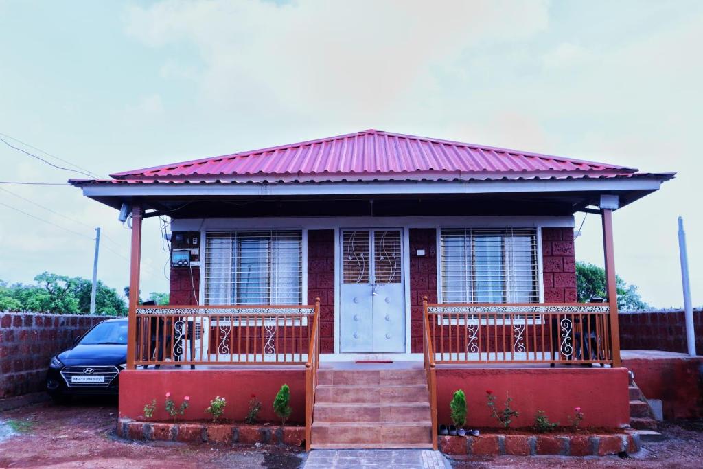 a small red house with a red roof at Keshav Villa Sea View Holiday Home in Jāmb