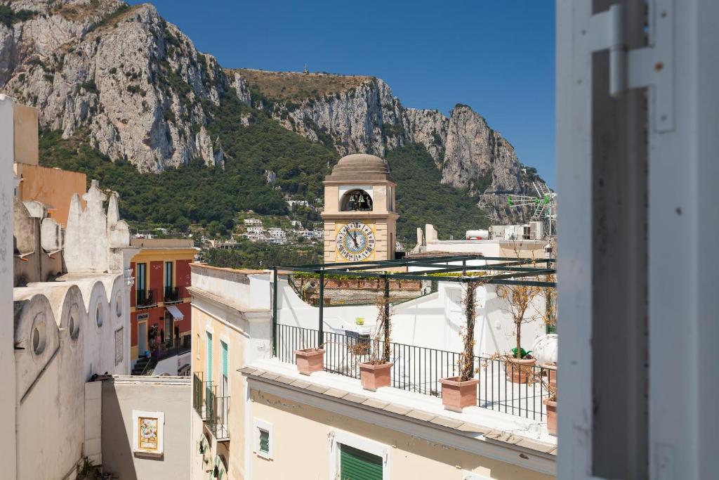 a clock tower on a building with a mountain in the background at Casa Raiola in Capri