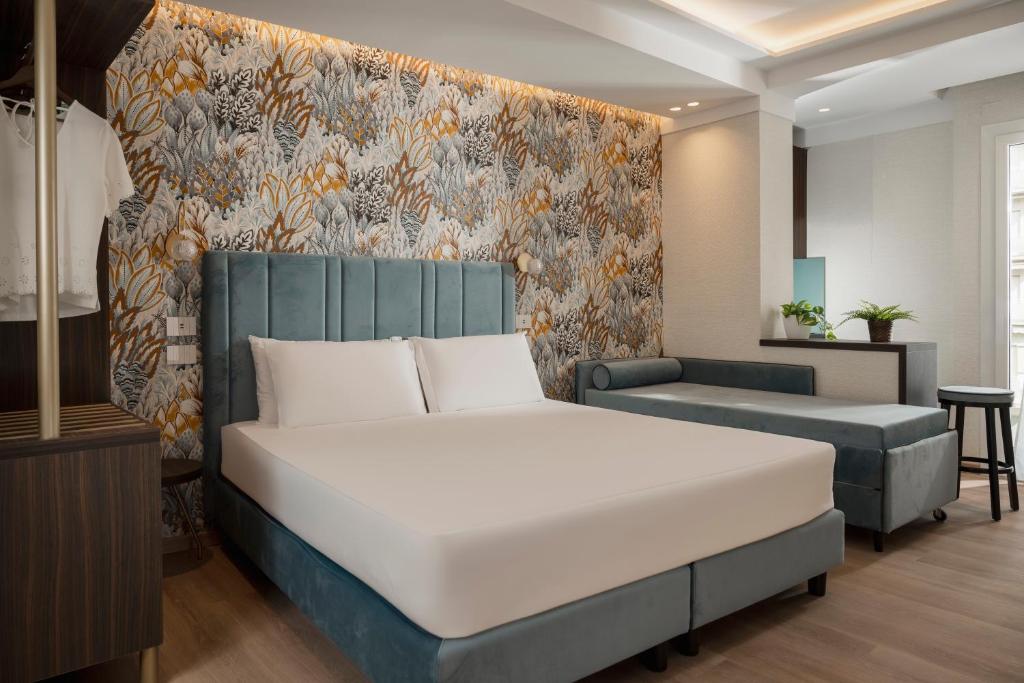 une chambre avec un grand lit et un canapé dans l'établissement Hotel Grazia Riccione, à Riccione