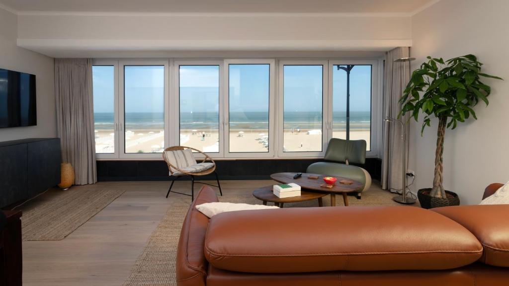 a living room with a couch and a view of the beach at Valdemosa one in De Haan