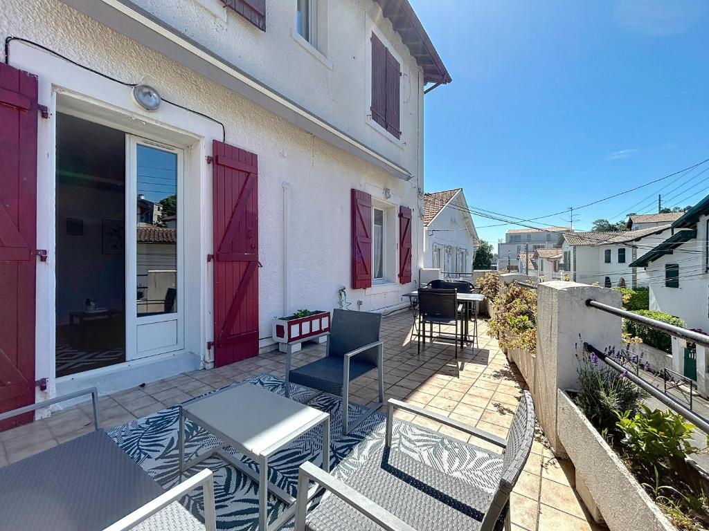 un patio avec une table et des chaises sur un balcon dans l'établissement Appartement de charme Erdizka classé 3 étoiles, à Bayonne