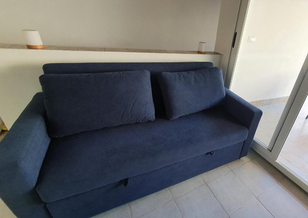 a blue couch sitting in a living room with two pillows at Casa Nonna Rosa in Balestrate