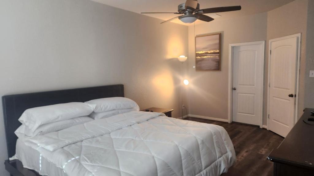 a bedroom with a white bed and a ceiling fan at Gayson Gardens Drive Richmond Texas USA in Richmond