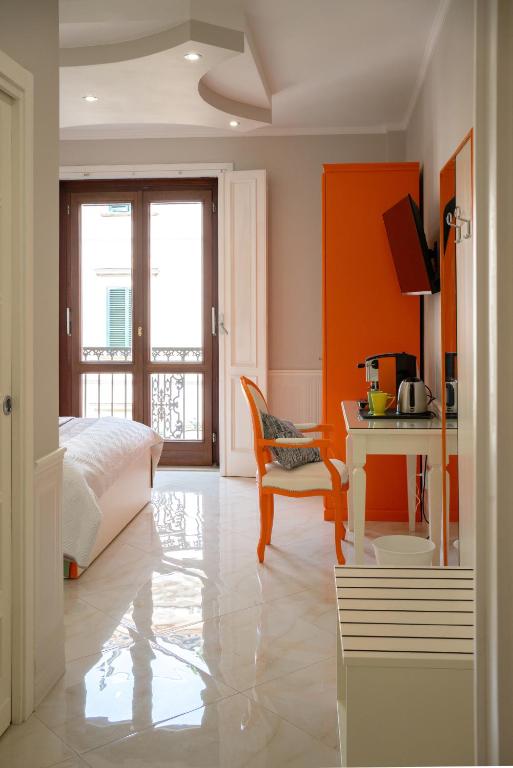 a bedroom with a bed and a desk with a table at Top Central Rooms in Caserta