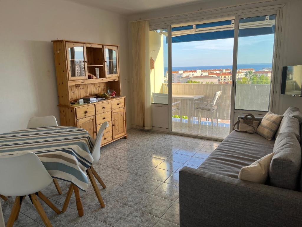 un salon avec un canapé et une table dans l'établissement T2 avec vue mer à 5 min de la plage, à Fréjus