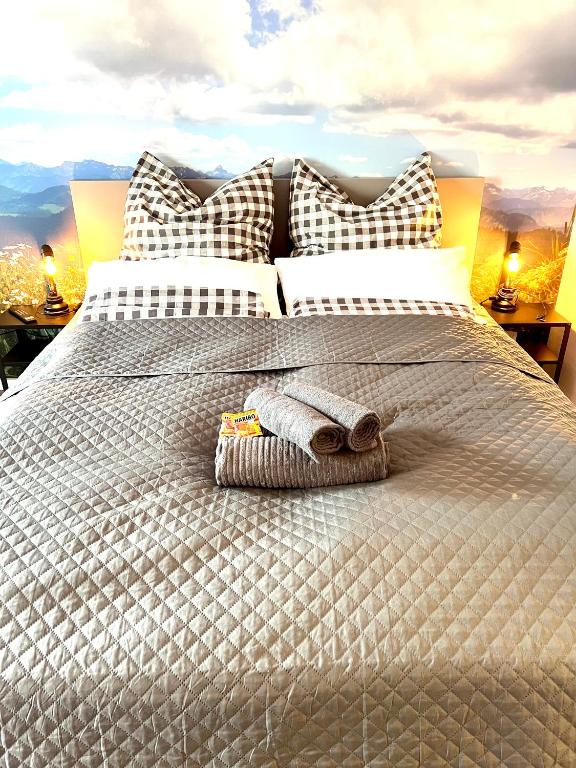 a bed with a blanket and a towel on it at Exklusive FeWo AllgäuStern Steibis mit WLAN Sauna Kamin und Oberstaufen PLUS Card mit SKIPASS in Oberstaufen