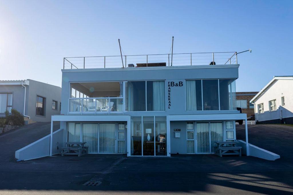 a blue building with glass doors in a parking lot at Franskraal Bed and Breakfast Pty Ltd in Franskraalstrand