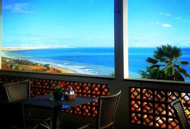 un restaurante con mesa y vistas al océano en Pousada do Holandês, en Canoa Quebrada