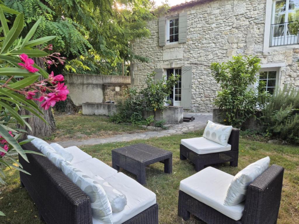 un jardin avec des canapés et des tables et un bâtiment dans l'établissement Sublime Mas de Lou à 15 minutes d'Arles, à Tarascon