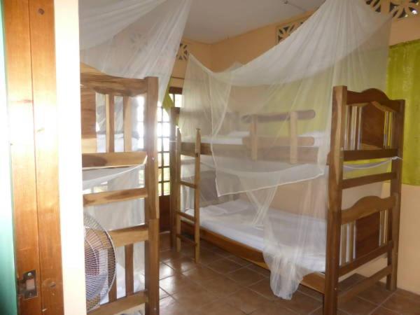 Centro Ecoturístico Flor de Pochote في El Pochote: غرفة نوم بسريرين بطابقين مع مظلة