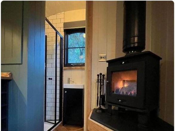 cocina con chimenea y fogones en Shepherds Hut, en Mawgan Porth