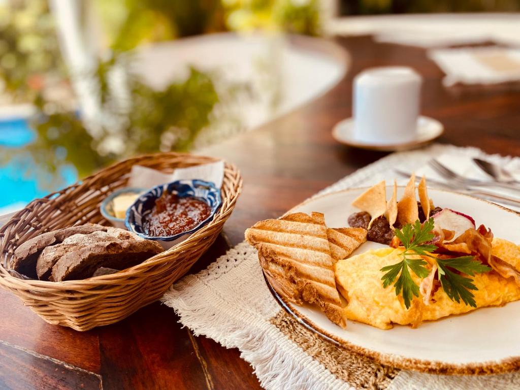 a table with a plate of food and a basket of bread at Hotel Para Ti - Adults Only in Holbox Island