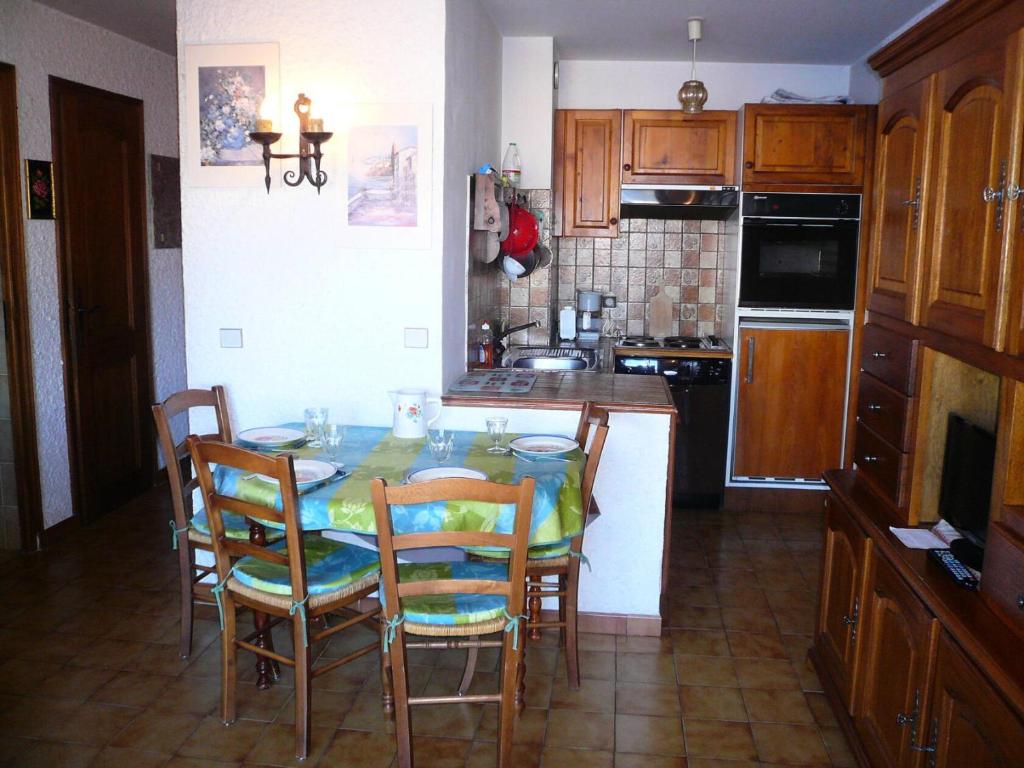 une cuisine avec une table et des chaises ainsi qu'une cuisine avec une cuisinière dans l'établissement Résidence Les Terrasses Du Mont Blanc - 2 Pièces pour 6 Personnes 17, à Combloux