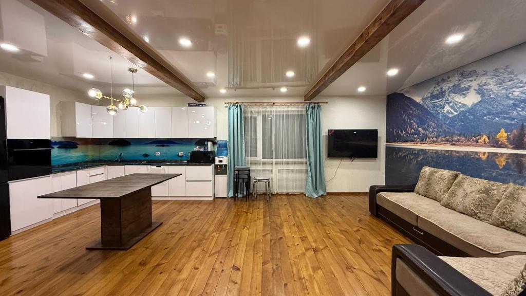 eine Küche und ein Wohnzimmer mit einem Tisch und einer Couch in der Unterkunft Wood house ukg in Öskemen