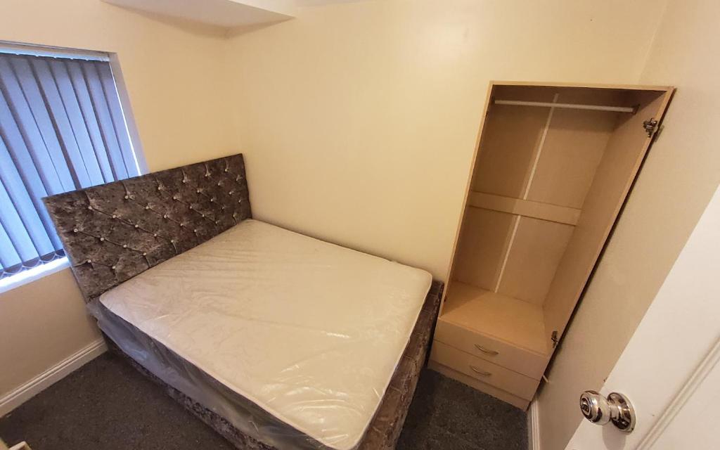 a small bedroom with a bed and a closet at Sure stay property in Bolton