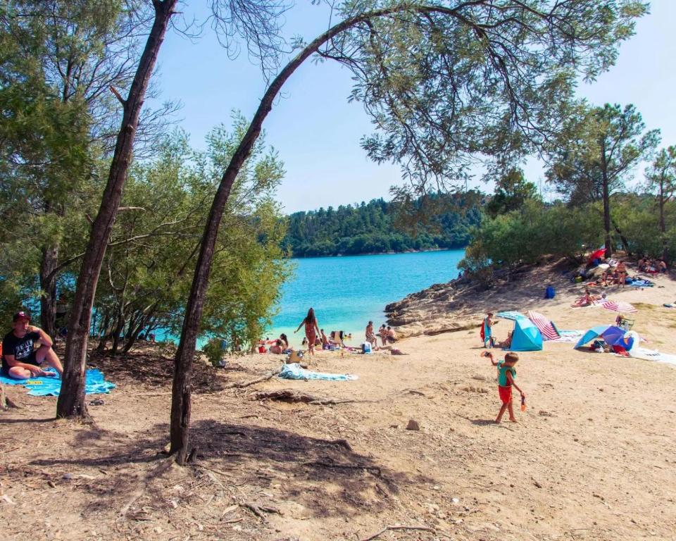 a group of people on a beach near a body of water at Os Marias in Tomar