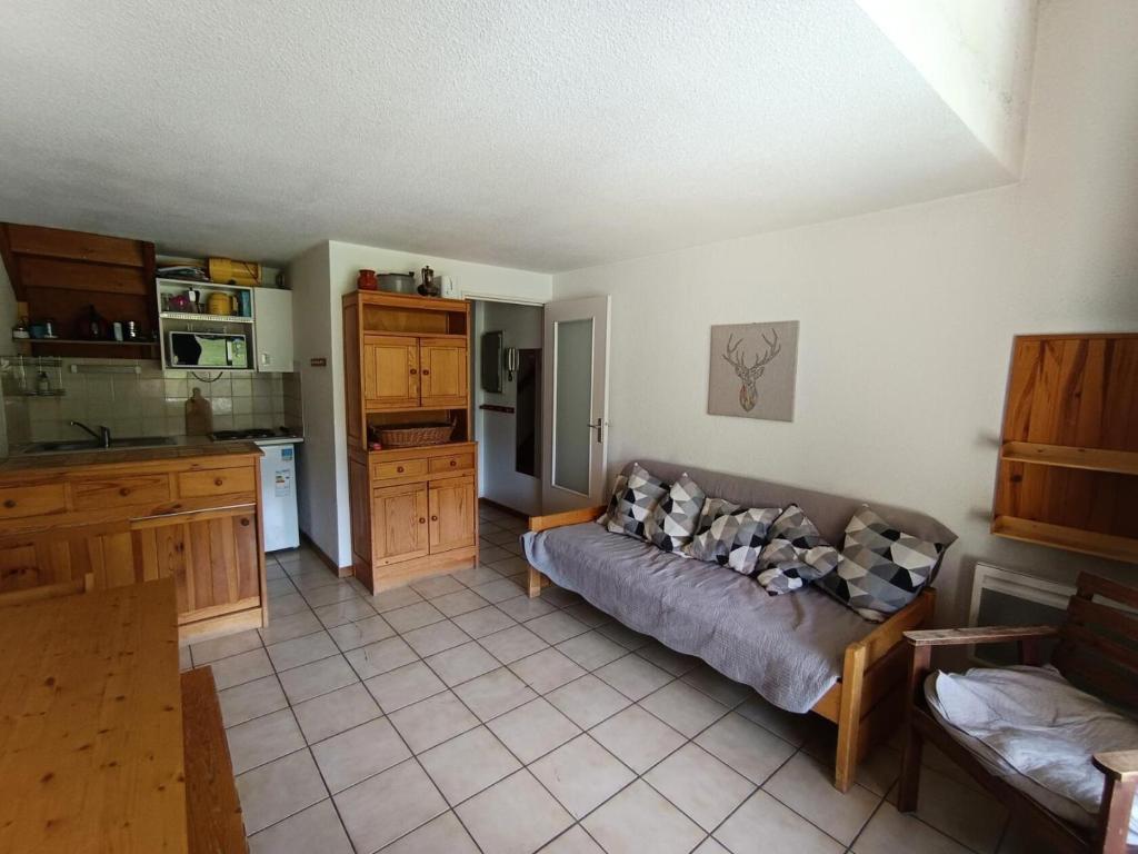 un salon avec un canapé et une cuisine dans l'établissement Résidence Golf - 3 pièces 6 personnes en duplex - Face aux pistes MAE-8914, à Montgenèvre