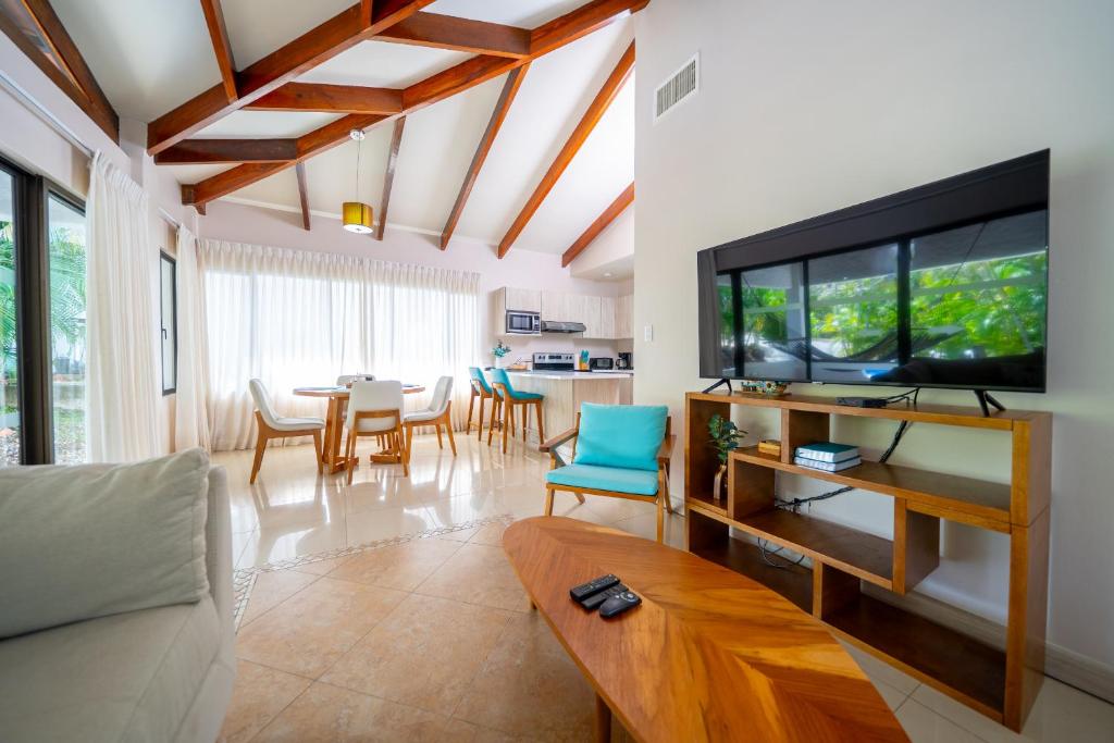 a living room with a tv and a table with chairs at Villa Serenidad Costera in Sardinal